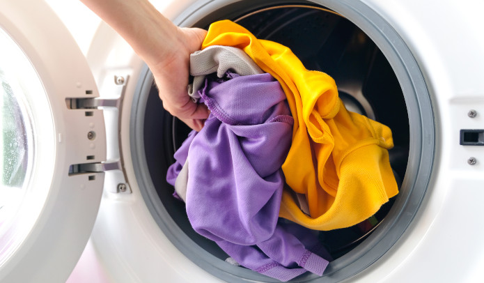 Waschmaschine wird mit Sportkleidung befüllt