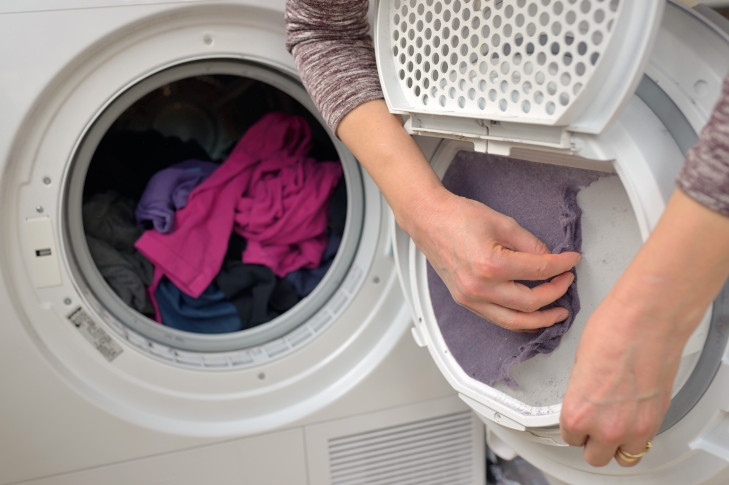 Das Flusensieb einer Waschmaschine wird gereinigt