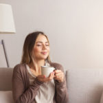 eine Frau mit einem frisch gebrühten Kaffee in der Hand