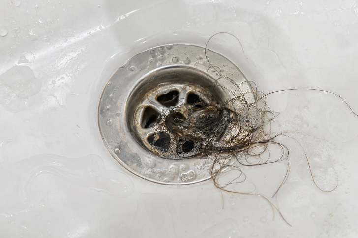 Haare und Seifenreste im Badewannenabfluss