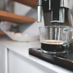 Kaffemaschine und ein gefüllter Kaffee davor