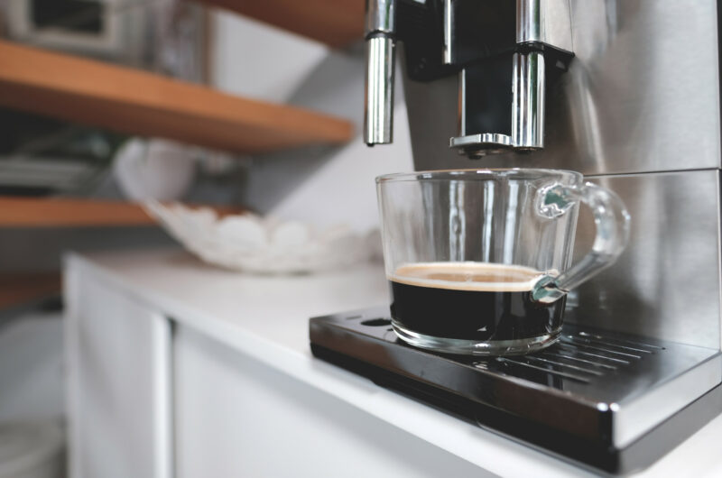 Kaffemaschine und ein gefüllter Kaffee davor