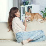 Eine Frau und ihre Katze sitzen auf der Couch
