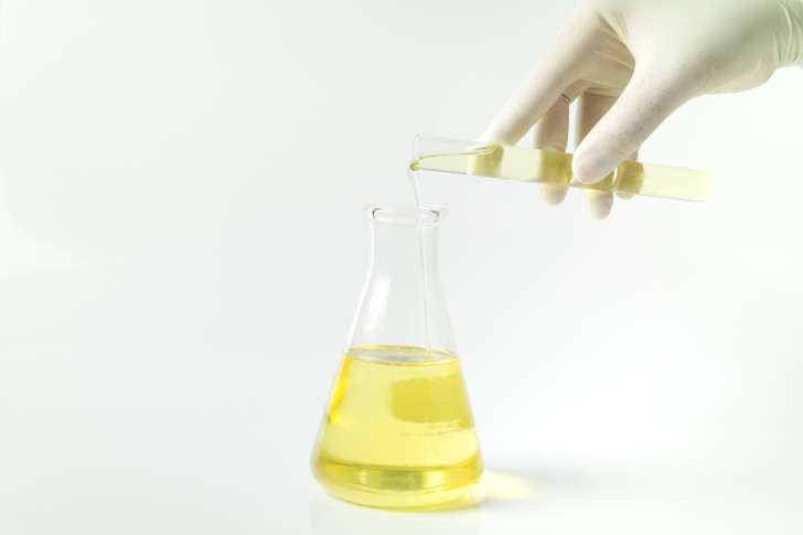Reagenzglas wird mit gelber Flüssigkeit befüllt