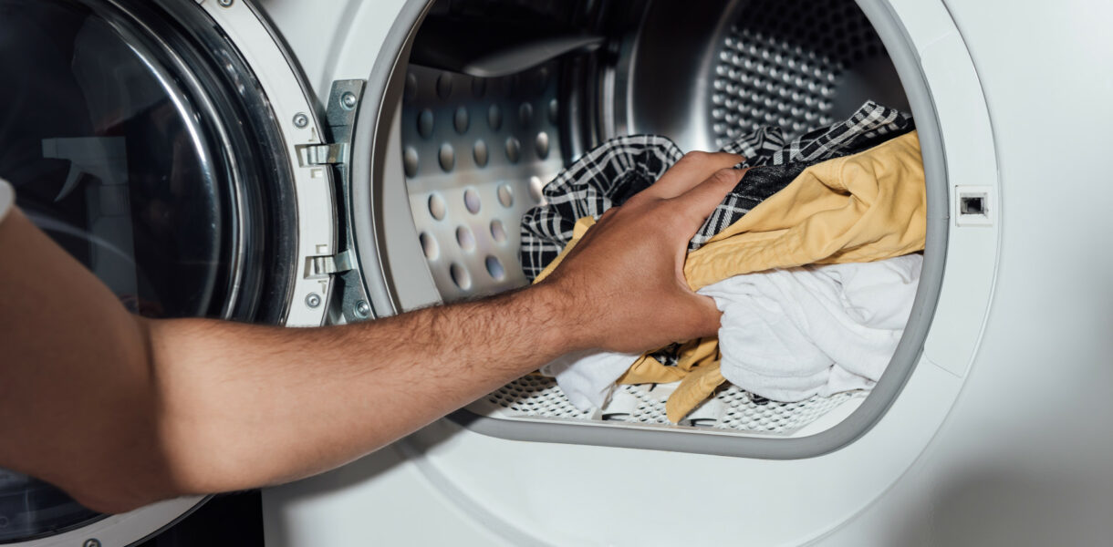 Wäsche wird aus der einer Waschmaschine geholt