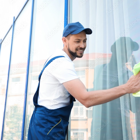 Gebäudereiniger putzt eine Fensterscheibe