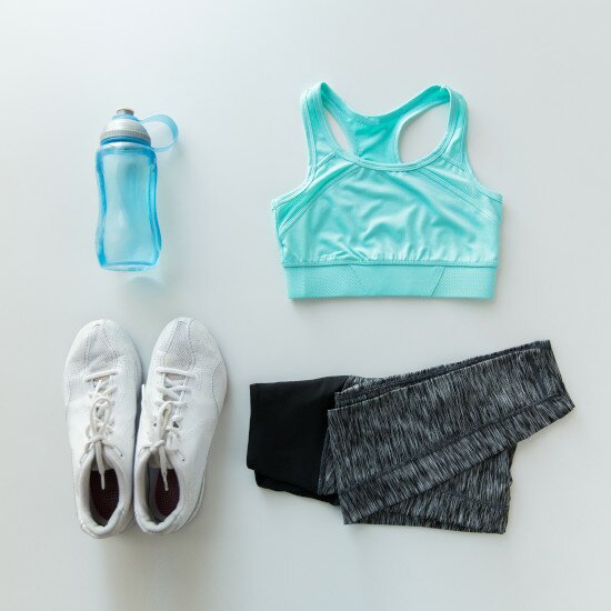 Mikroben im Sportwaschmittel unterstützen beim tragen Ihrer Sportkleidung die hauteigene Bakterienflora Sportschuhe, Sportkleidung und eine Trinkflasche in türkis und grautönen