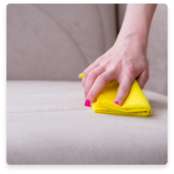 ein Sofa wird mit einem gelben Putztuch geputzt