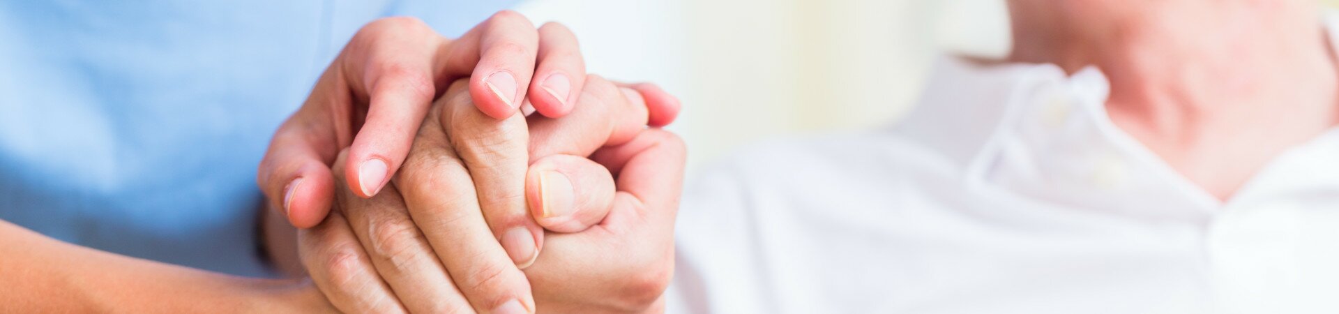 Pflegerin hält die Hand eines alten Mannes wird gehalten
